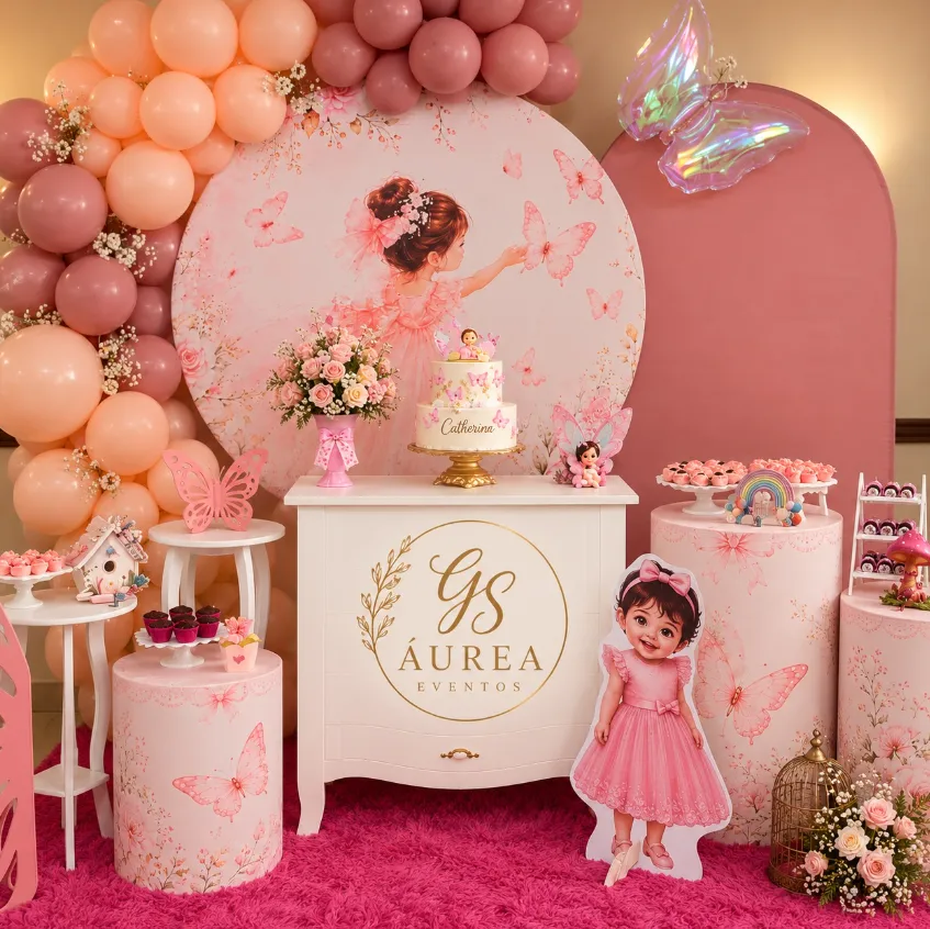 Mesa de festa com painel redondo de menina com borboletas, arco de balões rosé e pêssego e cômoda branca com bolo
